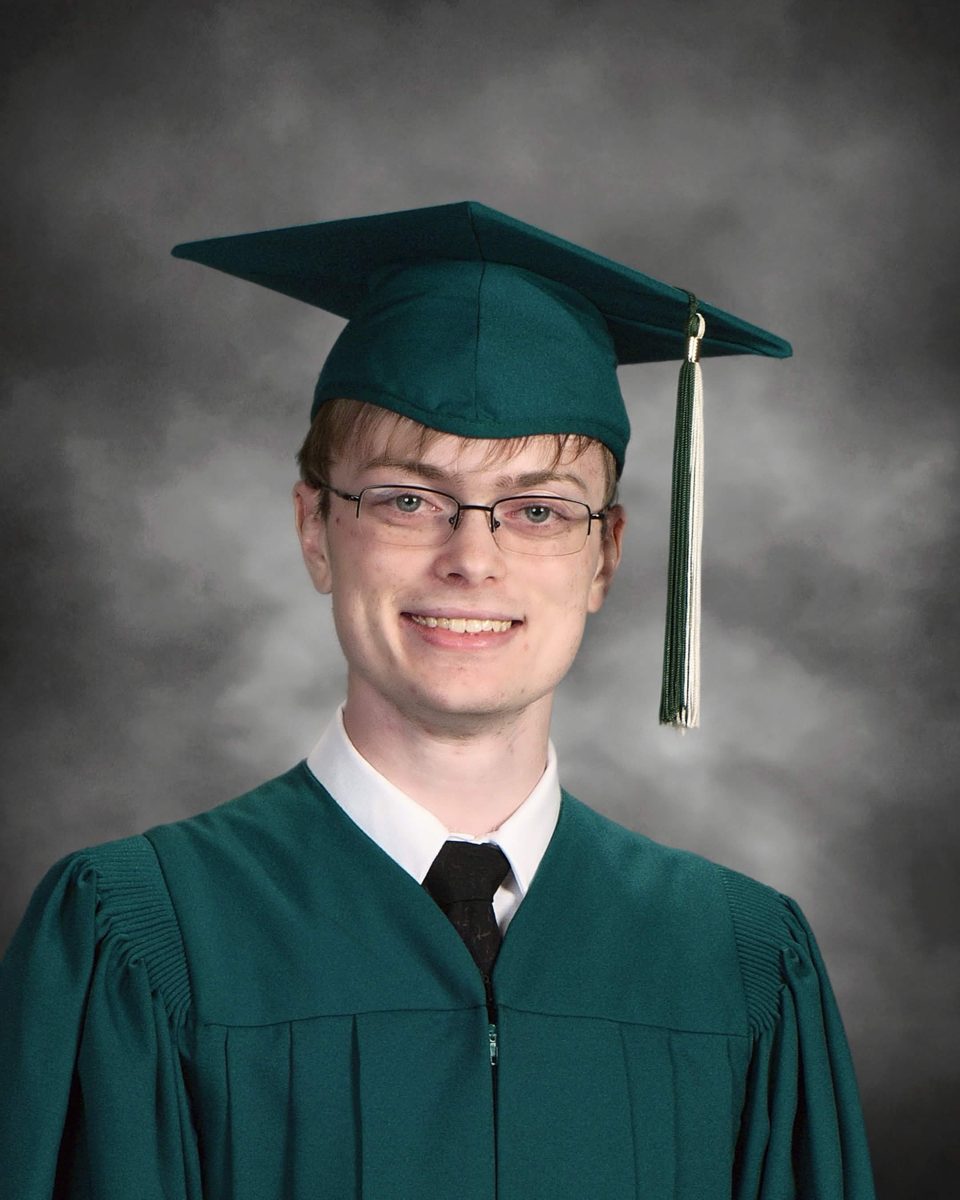 Graduation portrait of Jacob in a green cap and gown.